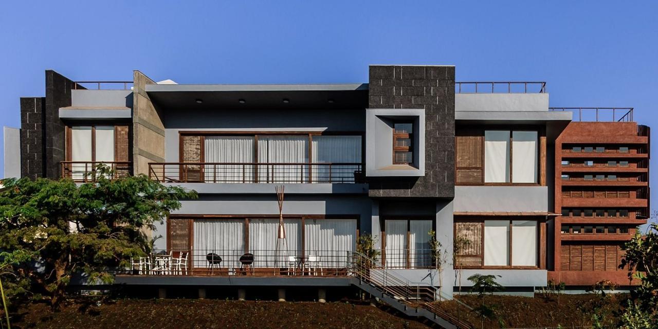 House of Selective Vision — a contemporary hillside residence at Aamby Valley, Lonavala, in layered stone and terracotta louvers